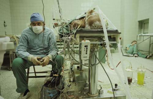 Доктор Релига контролирует жизненно важные органы своего пациента после 23-часовой (успешной) пересадки сердца. Его помощник спит в углу, 1987 год.