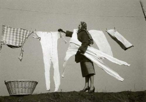Домохозяйка снимает замороженные кальсоны со стиральной линии, 1940-е годы.