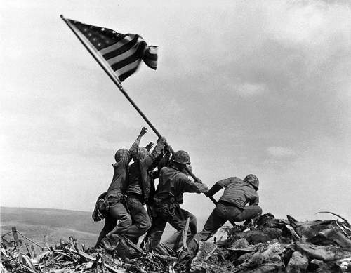 Солдаты 28-ого полка, 5-ой дивизии военно-морских сил США поднимают американский флаг на горе Suribachi, Iwo Jima, Япония. 23 февраля 1945 года. By Joe Rosenthal/A.P. Photo.