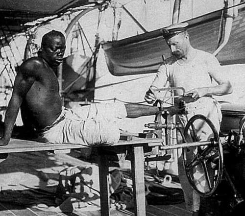 Британский моряк снимает ножные цепи с раба, который носил их три года